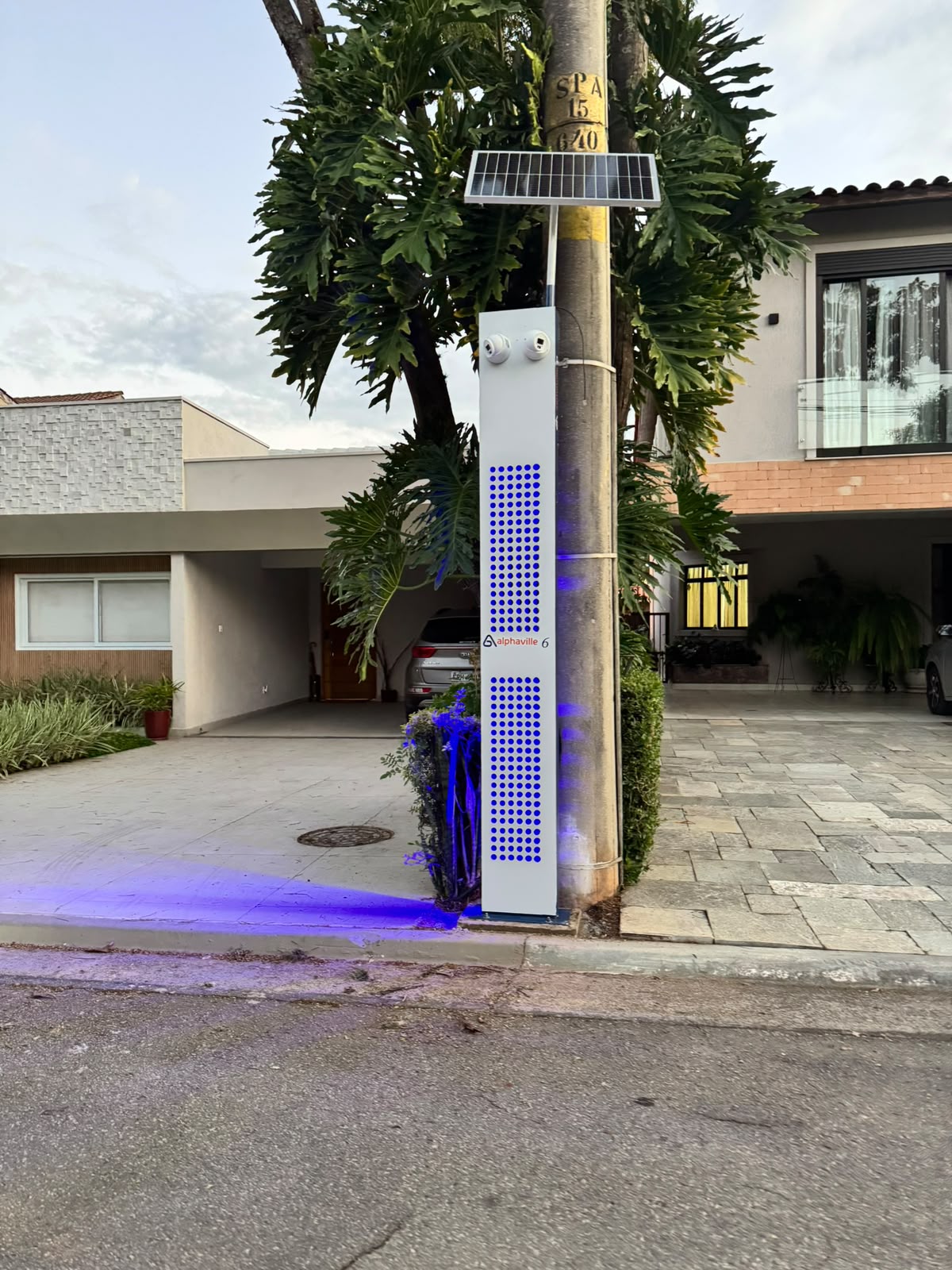 Referência de totem de monitoramento com câmeras e painel solar em uma via residencial